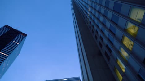 Low-Angle-Spinning-Shot-of-Skyscrapers-in-the-Tokyo.-Financial-District.-Skyscape-and-Cityscape-in-the-Evening.