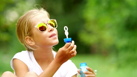 Niña-jugando-con-pompas-de-jabón-al-aire-libre.-Cámara-lenta.