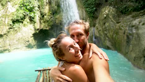 Junges-paar-unter-Selfie-Porträt-mit-einem-wunderschönen-Wasserfall