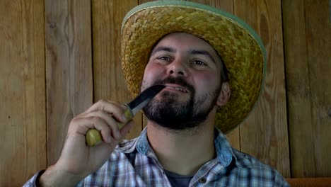 Bearded-man-with-a-straw-hat-and-a-knife