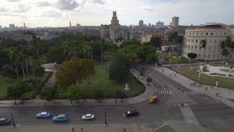 Ver-desde-arriba-en-taxi-de-coches-clásicos-de-conducción-en-la-calle-principal,-vista-de-la-ciudad-de-la-Habana,-Cuba