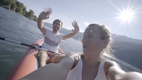 Joven-pareja-en-vacaciones-de-verano-disfrutando-de-canoa-en-el-lago-en-las-montañas.-Gente-de-viaje-divertido-concepto-de-vacaciones.-Tecnología-y-juventud-cultura-selfie---4K