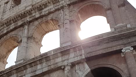 A-ray-of-sun-passes-through-the-arches-of-the-Colosseum-in-Rome,-Italy.