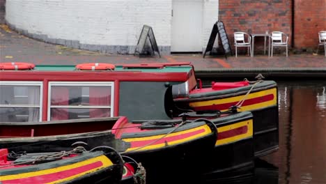 Close-Up-of-Three-Narrow-Boat-Barges-Lined-in-a-Row