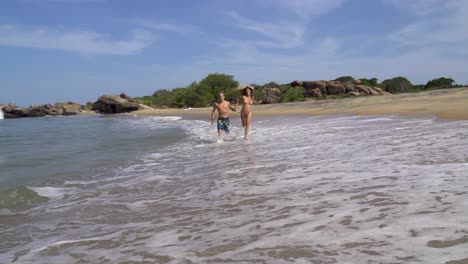 SLOW-MOTION:-Young-couple-running-in-shallow-water