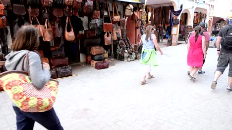 Gente-caminando-en-la-parte-frontal-de-una-tienda-que-vende-de-bolsos-de-cuero