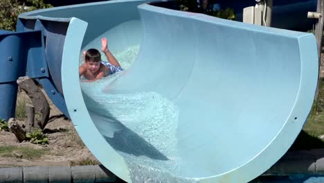 Slow-motion-of-happy-boy-on-water-slide,-South-Africa