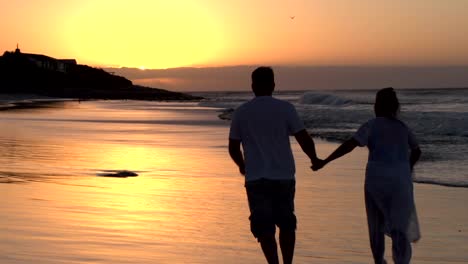 Pareja-romántica-a-lo-largo-de-la-playa-en-silueta-de-Ciudad-del-Cabo,-Sudáfrica