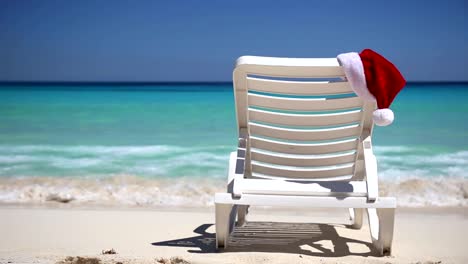 Santa-Claus-Hut-auf-dem-Liegestuhl-in-der-Nähe-des-tropischen-ruhigen-Strand