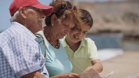 Familia-abuelos-y-niño-en-días-festivos-en-Cuba-lectura-mapa-turístico