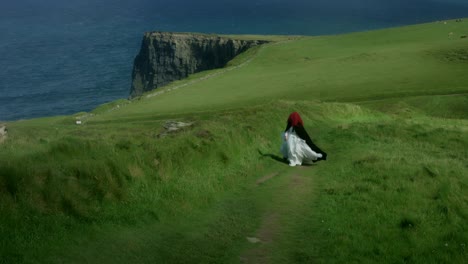 4k-Shot-of-a-Redhead-princess-walking-on-Cliffs-of-Moher-View-in-Ireland