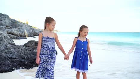 Two-little-sisters-walking-by-the-sea-on-the-white-beach