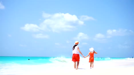 Little-adorable-girl-and-young-mother-at-tropical-beach.-Family-of-two-have-a-lot-of-fun-during-summer-vacation