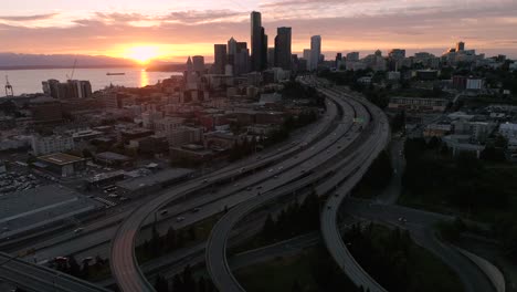 Erstaunlichen-Sonnenuntergang-Antenne-von-Seattle,-Washington-mit-pulsierenden-Orange-Leuchten-auf-Wolkenkratzer-Gebäude-in-der-Skyline-der-Stadt