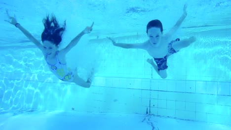 Underwater-footage-of-kids-jumping-and-diving-in-a-swimming-pool