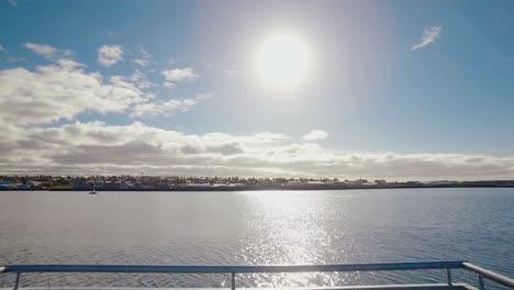 moving-shot-on-a-wooden-pier,-showing-panorama-of-Reykjavik-from-city-beach