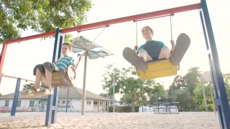 Kinder-schwingen-zusammen-auf-einem-öffentlichen-Spielplatz