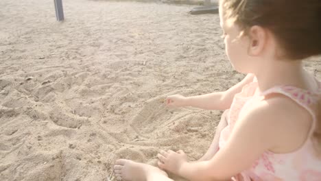 Kleines-Mädchen-in-einer-Sandbox-auf-einem-Spielplatz-spielen