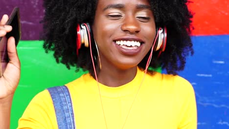 Escuchar-música-de-chica-guapa-con-sus-auriculares-con-colores-de-fondo