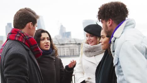 Freunde-zu-Fuß-entlang-Südufer-bei-Winter-Besuch-in-London