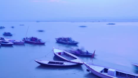 Indian-pilgrims-rowing-boat-in-dawn,-Ganges-river-in-Varanasi,-India.