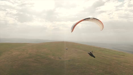 Athlet-Gleitschirm-fliegt-auf-seinem-Gleitschirm-neben-die-Schwalben.-Follow-up-Aufnahmen-aus-der-Drohne