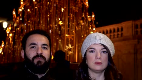 Retrato-de-sonriente-pareja-riendo-en-la-calle-en-la-noche-de-invierno,-mirando-cámara-