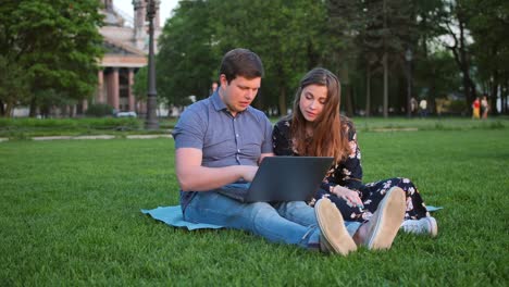 Young-Beautiful-Couple-Looking-at-Laptop-and-Laughing