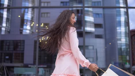 Girl-in-a-dress-after-shopping-with-bags-in-hands.-4K