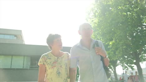 active-senior-caucasian-tourist-couple-walking-in-london-backlit-by-the-sun