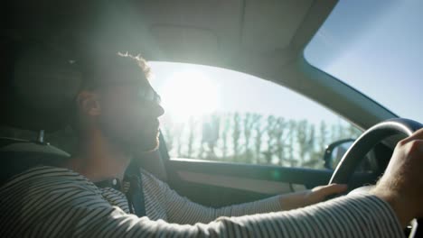 hombre-solo-es-conducir-automóvil-en-campo-en-día-soleado,-usa-gafas-de-sol,-con-volante,-inclinación-vista