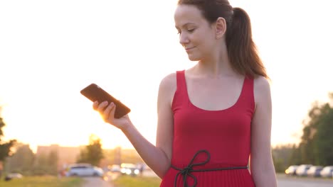 Glückliche-Frau-im-roten-Kleid-mit-Smartphone,-Stadt-Lifestyle-Konzept