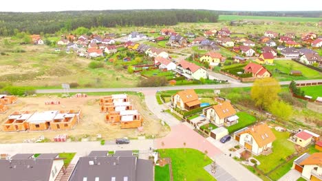 Camera-flight-over-new-family-houses-and-construction-site-in-suburban-district.-Construction-industry-and-economic-growth-in-European-Union.