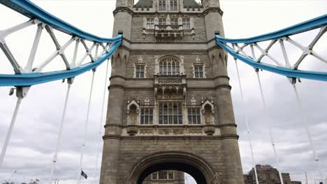 Low-angle-view-drone-dolly-shot-under-the-iconic-Tower-Bridge-in-London,-Great-Britain