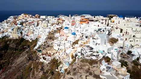 Sobrevuelo-de-la-ciudad-de-Oia,-isla-de-Santorini,-Grecia