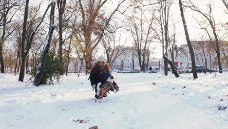 Junge-Frau-im-Winter-durch-den-Park,-Dolly-Schuss-mit-Jack-Russell-Terrier-spielen