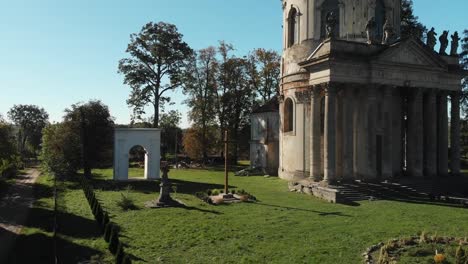 Holzkreuz-und-Ruinen-einer-katholischen-Kirche-mit-Steinstatuen