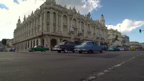 iconic-view-of-classic-american-1950s-cars-driving-on-main-street-in-Havana,-Cuba,-low-angle-shot