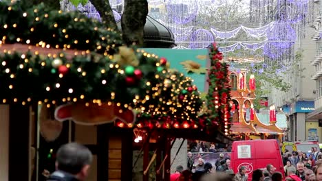 Pull-Focus-through-Twinkling-Xmas-Lights,-Large-Crowd-German-Christmas-Market