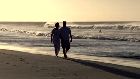 Couple-enjoying-romantic-walk-along-the-beach-in-silhouette,-Cape-Town,South-Africa