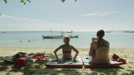 Two-girls-sunbathing-on-the-beach
