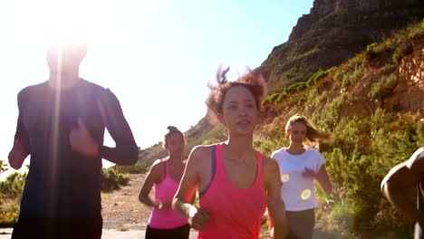 Multi-ethnic-group-of-athletes-running-on-a-footpath