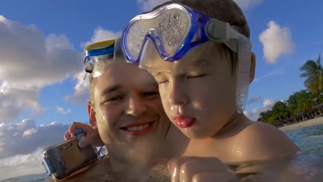 Slow-motion-view-of-happy-young-father-with-son-in-the-water-in-snorkeling-masks,-Port-Louis,-Mauritius-Island