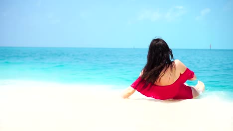 Young-beautiful-woman-lying-at-shallow-tropical-water