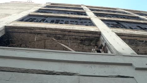 LOW-ANGLE-VIEW:-Broken-glass-on-the-windows-of-old-abandoned-industrial-building