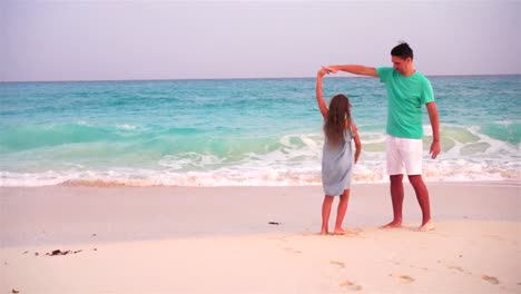 Niña-y-feliz-papá-divertirse-durante-las-vacaciones-en-la-playa