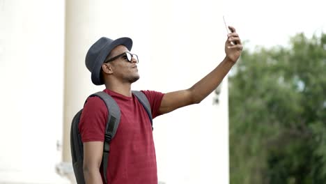 African-american-tourist-man-having-online-video-chat-using-his-smartphone-camera-while-travelling-in-Europe