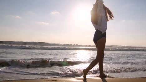 Mujer-feliz-caminando-y-spinning-en-la-playa-cerca-del-océano.-Joven-hermosa-chica-disfrutando-de-la-vida-y-la-diversión-a-la-orilla-del-mar.-Vacaciones-de-verano-o-vacaciones.-Paisaje-de-naturaleza-en-el-fondo