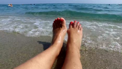 salpicaduras-de-olas-de-agua-en-piernas-mujer-agradables-en-la-playa