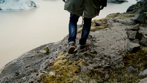 Schönen-jungen-Mann-zu-Fuß-über-die-Felsen-in-den-Bergen-in-der-Nähe-der-Vatnajökull-Eis-Lagune-in-Island